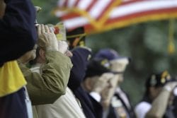 Veterans Salute the US Flag during Memorial Day service.